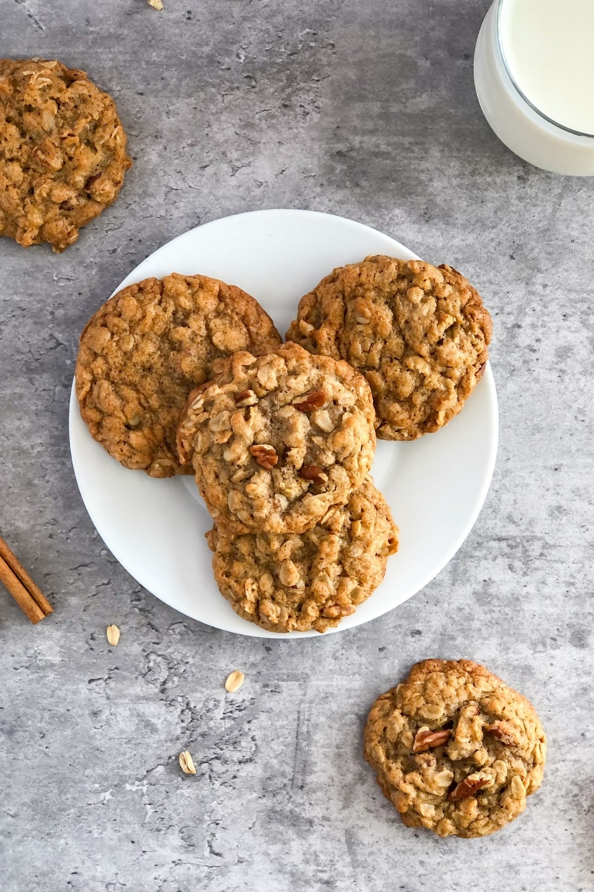 chai oatmeal cookies with pecans on a plate with a glass of milk