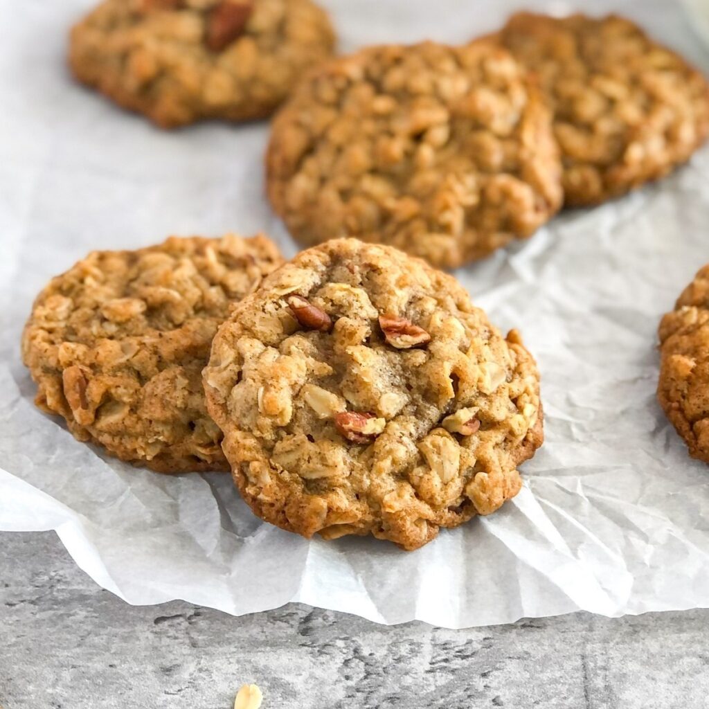 chai-spiced oatmeal cookies with pecans sitting on wrinkled white parchment paper