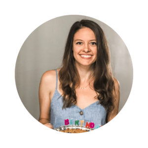 a woman with brown hair holding a cake