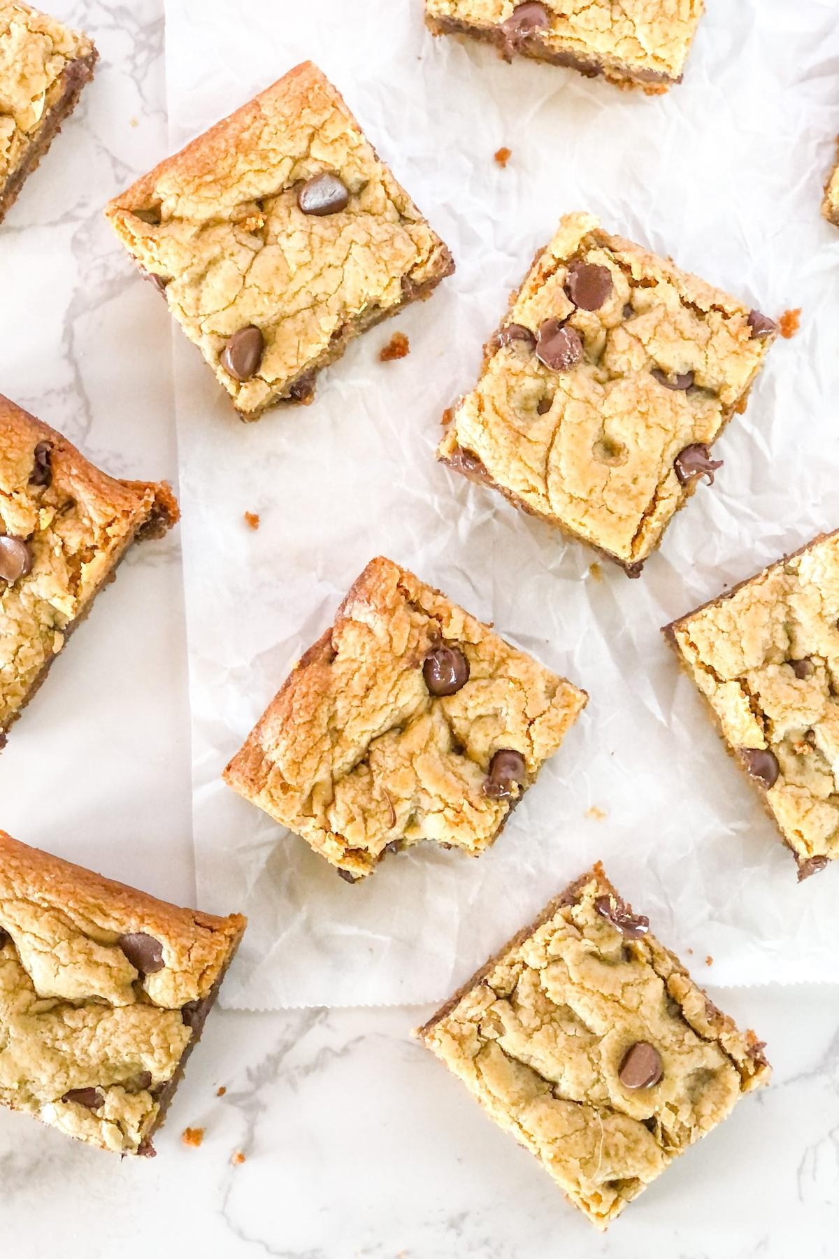 flat lay of peanut butter cookie bars with chocolate chips on parchment paper