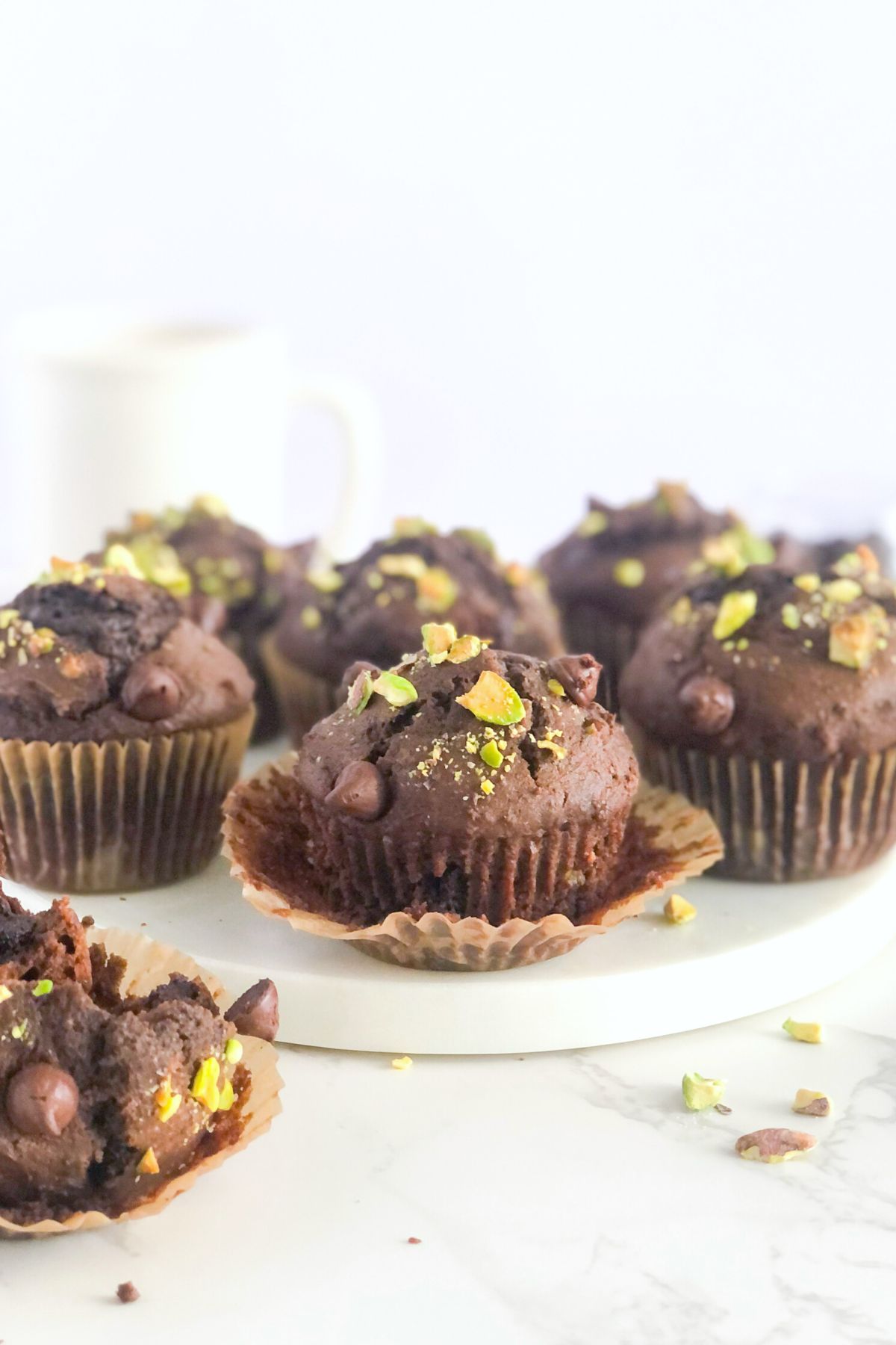 double chocolate pistachio muffins with a white coffee mug