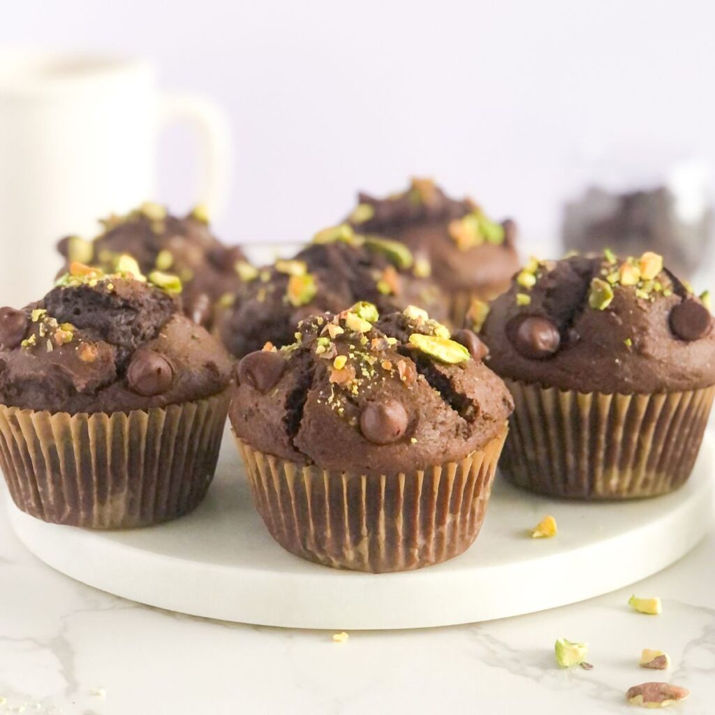 chocolate pistachio muffins on a white marble platter
