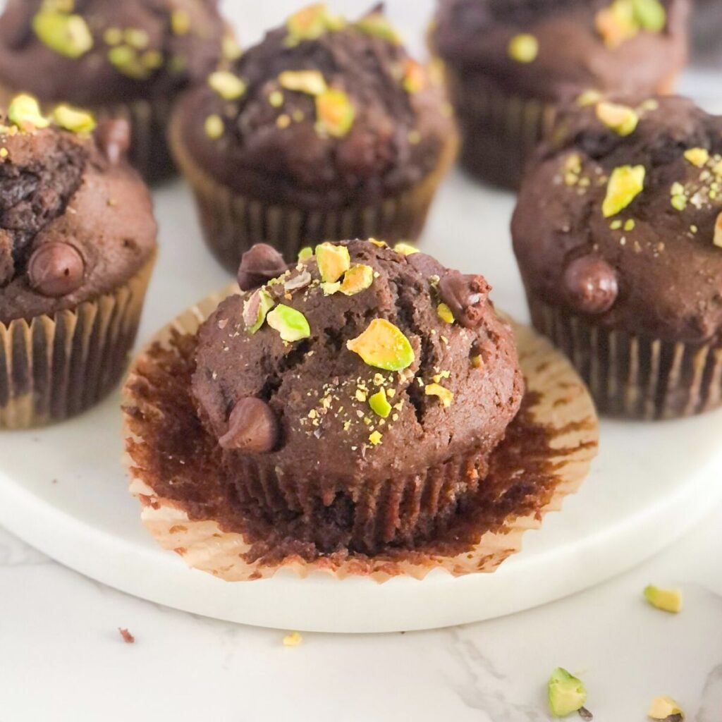 double chocolate muffins with pistachios on a white marble slab