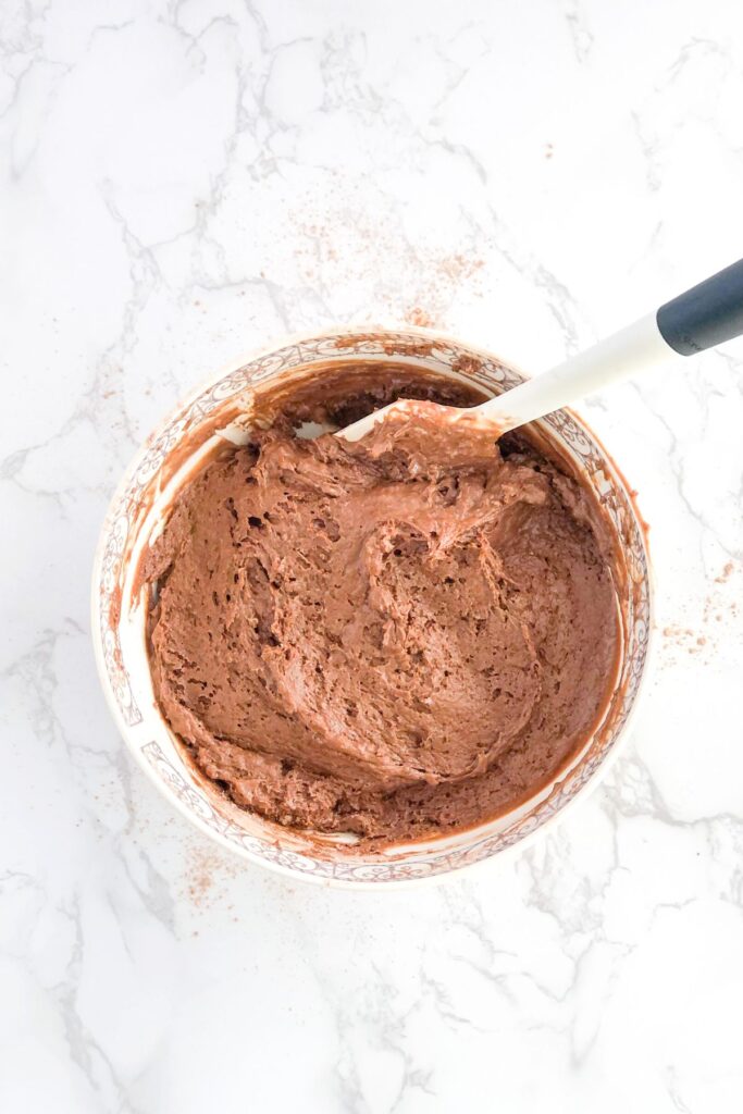 chocolate muffin batter in a bowl with a spatula