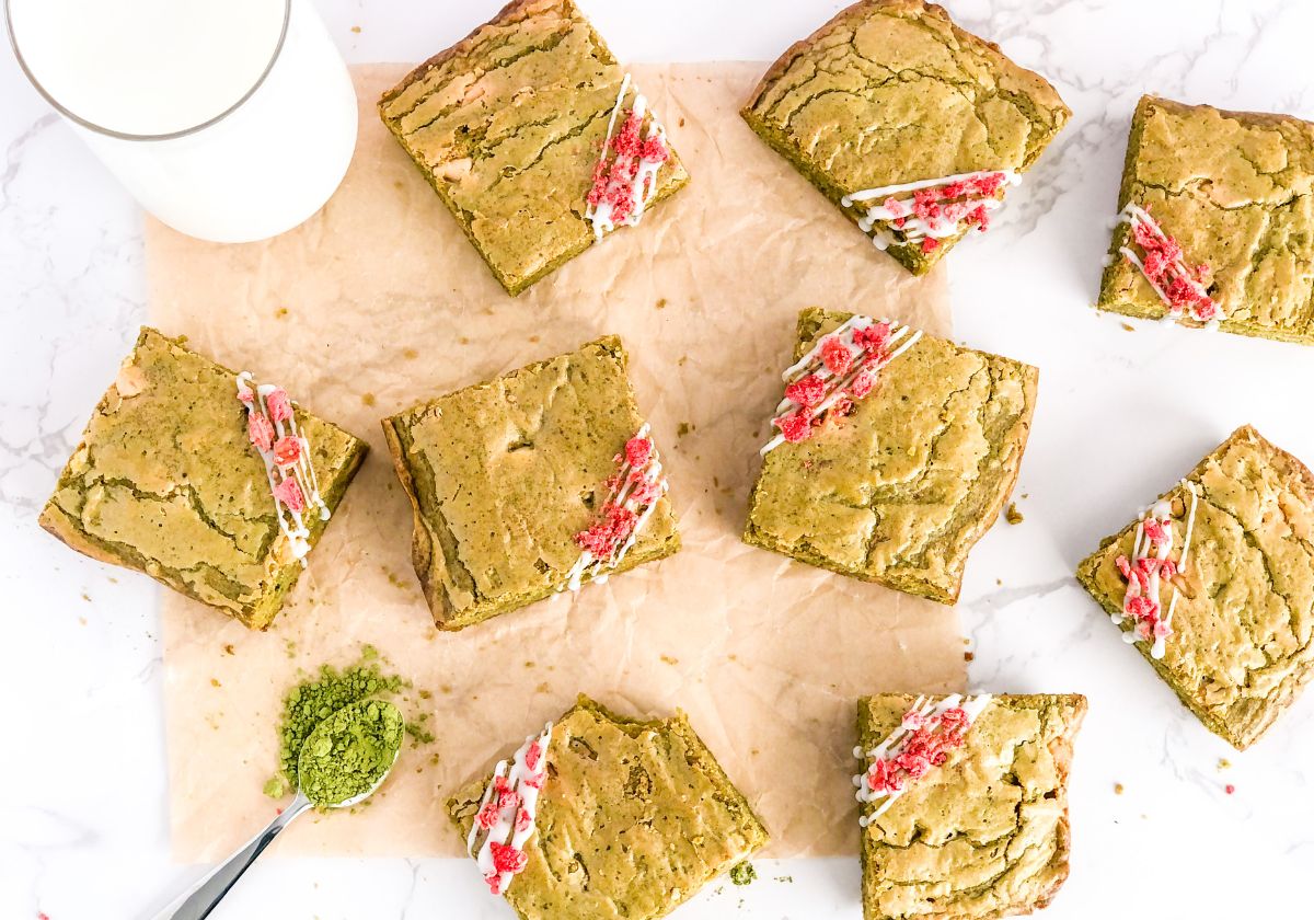 white chocolate matcha brownies with icing drizzle and crushed dried strawberries on top