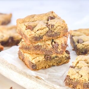 stack of peanut butter chocolate chip cookie bars on parchment paper