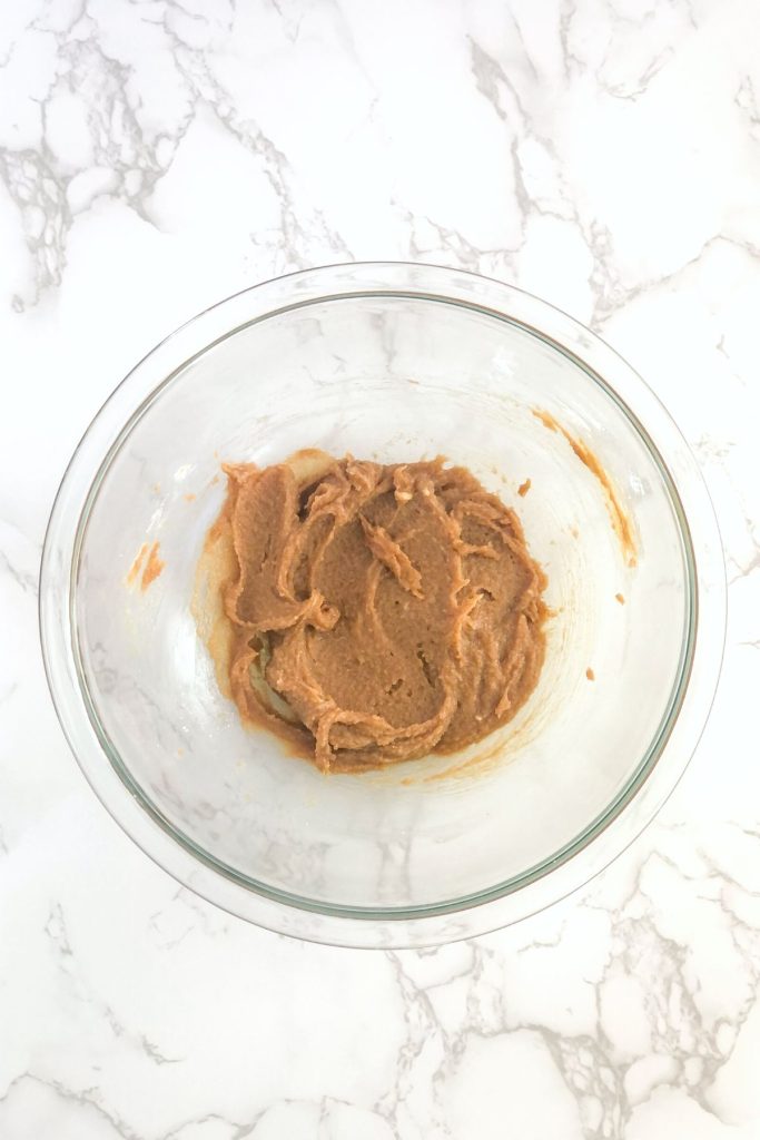 cookie butter spread and melted butter mixed together in a glass bowl
