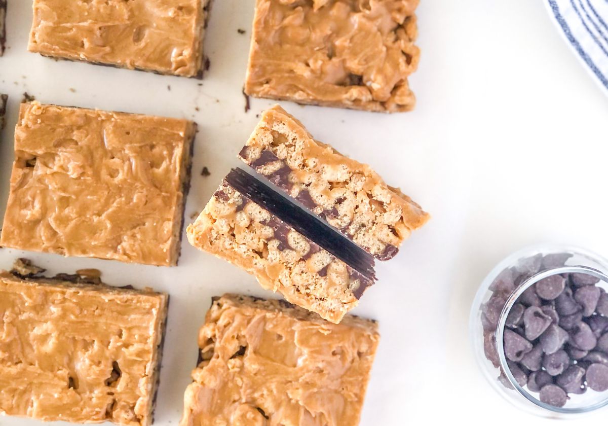 chocolate peanut butter cheerio bars next to a small bowl with chocolate chips